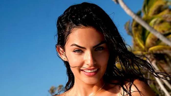 Alyssa Miller poses before vibrant green palm trees sporting wet hair.